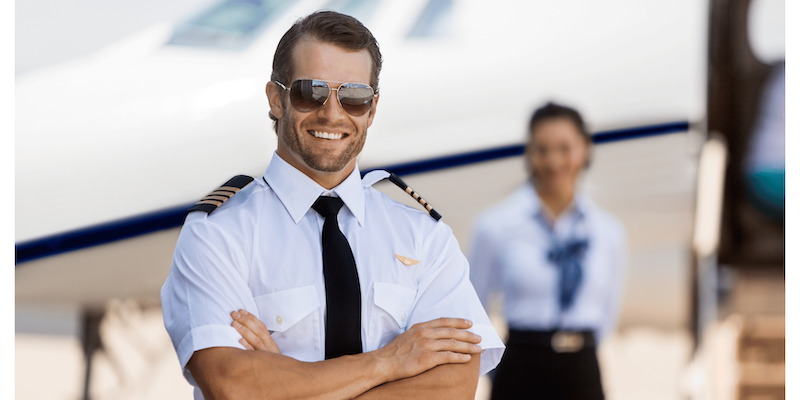 A captain standing infront of a charter flight about to take off